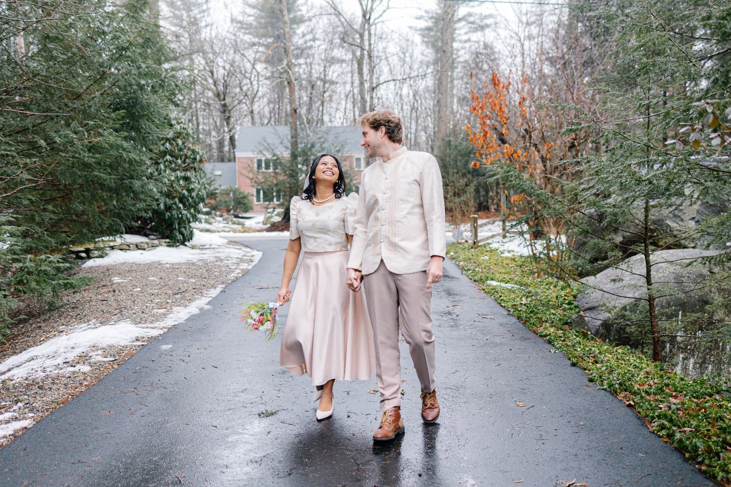A couple walks on a wet street after a surprise rain on their wedding in Boston.