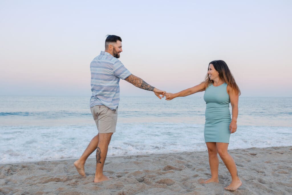 What to wear for a portrait session in Boston featuring couple in neutral outfits at the beach.