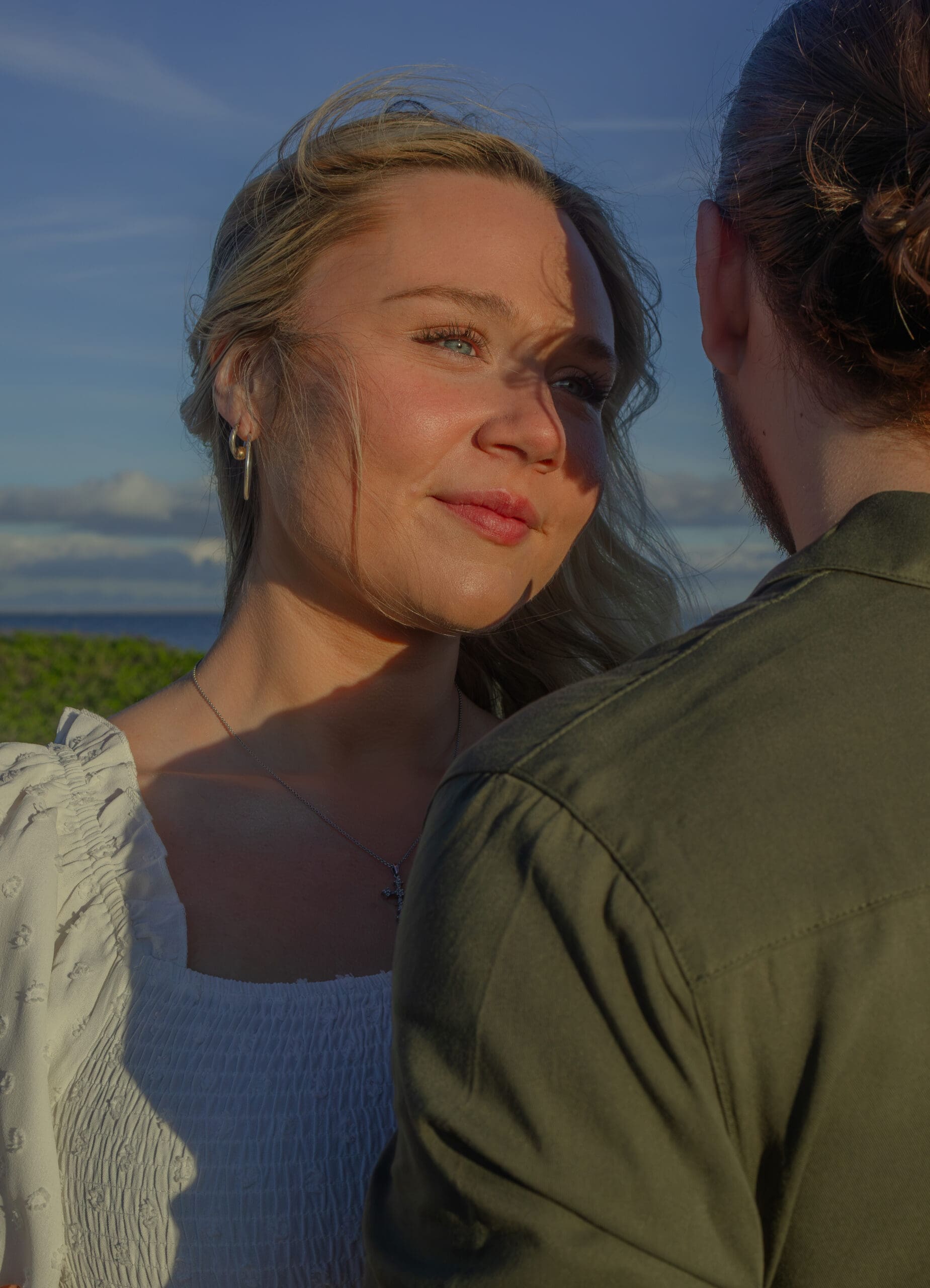 Couple holding hands on Boston beach during golden hour