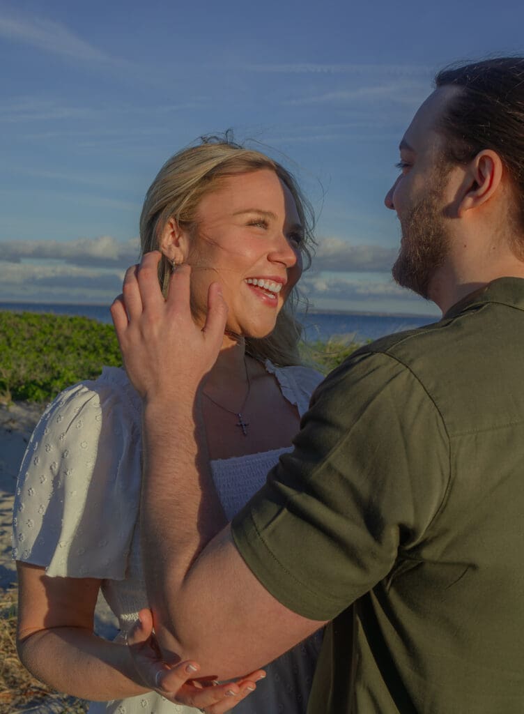 Couple holding hands on Boston beach during golden hour